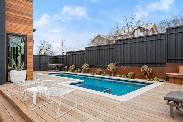 view of swimming pool with a fenced backyard, a fenced in pool, and a wooden deck