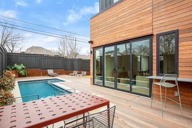 exterior space with a fenced backyard, a deck, and a fenced in pool