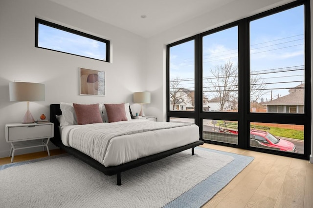 bedroom with multiple windows and wood finished floors