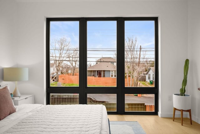 bedroom featuring radiator, baseboards, and wood finished floors