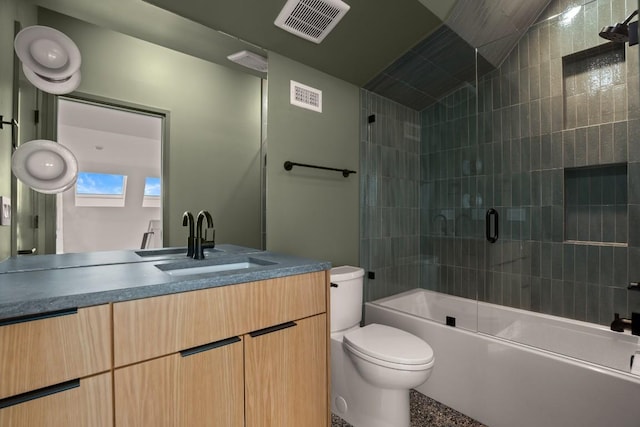 bathroom with toilet, visible vents, combined bath / shower with glass door, and vanity