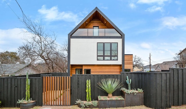 view of home's exterior with a fenced front yard and a gate