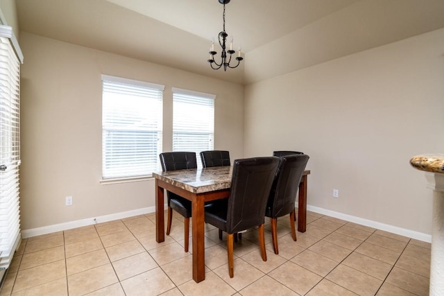 dining space featuring vaulted ceiling, a notable chandelier, baseboards, and light tile patterned floors