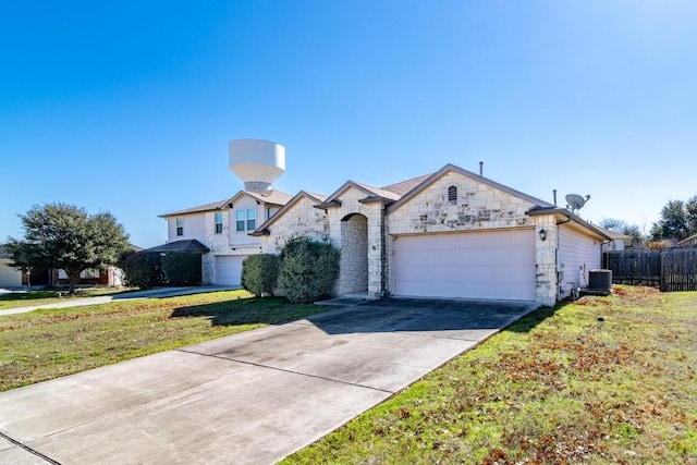 view of front of property featuring fence, concrete driveway, a front yard, central AC, and stone siding