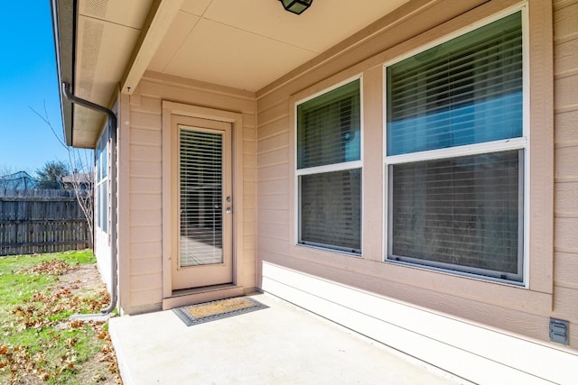 doorway to property featuring fence