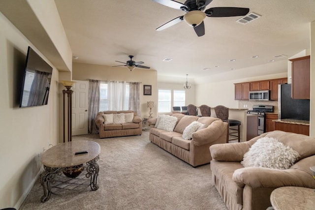 living room with light carpet, ceiling fan, and visible vents