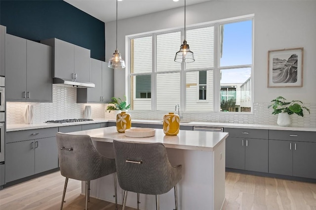 kitchen with plenty of natural light, gas stovetop, a kitchen island, and gray cabinetry