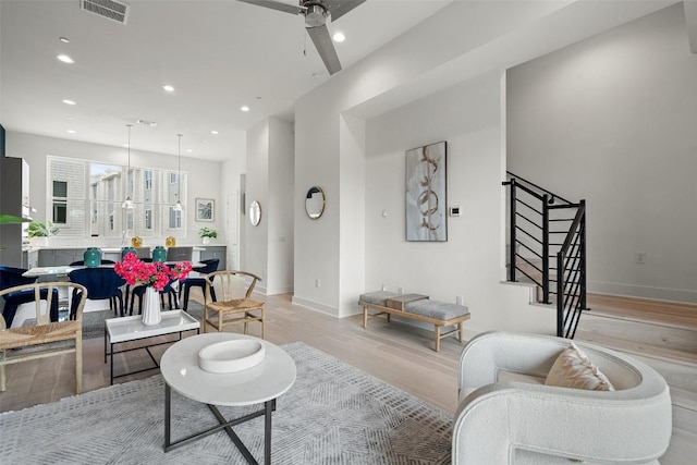 living area with recessed lighting, visible vents, a ceiling fan, stairway, and light wood finished floors