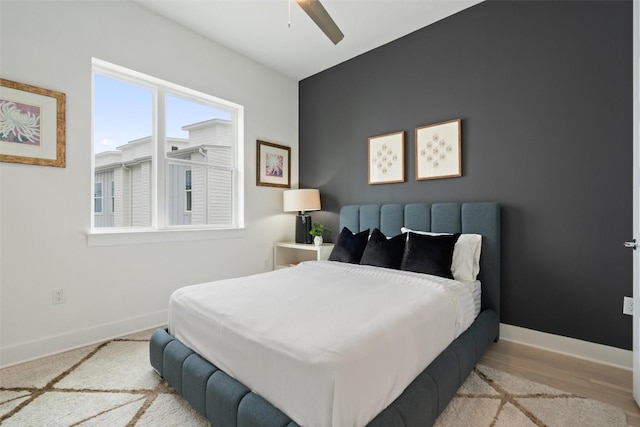 bedroom with wood finished floors, a ceiling fan, and baseboards