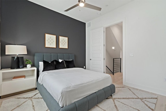 bedroom with baseboards, visible vents, ceiling fan, and wood finished floors