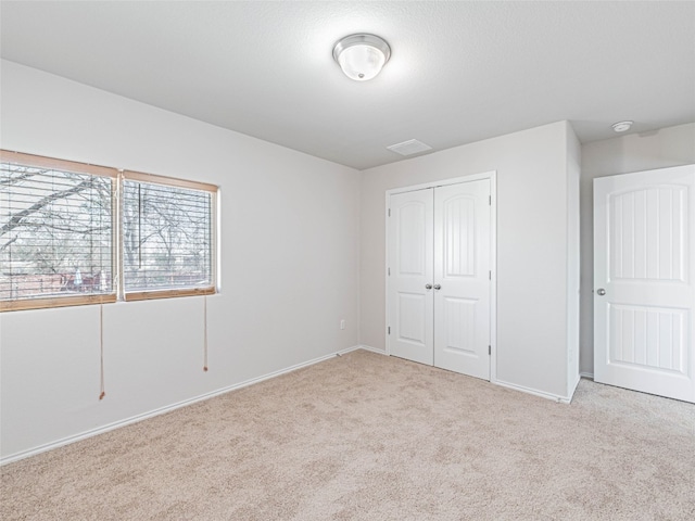 unfurnished bedroom with a closet, carpet flooring, and baseboards