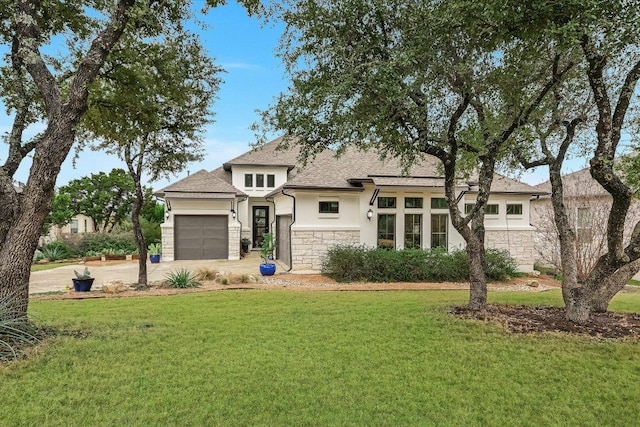 prairie-style home with a garage, stone siding, concrete driveway, stucco siding, and a front lawn