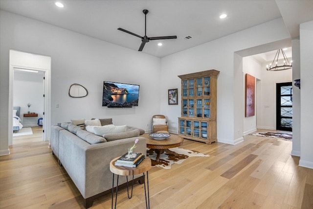 living room with recessed lighting, visible vents, light wood-type flooring, baseboards, and ceiling fan with notable chandelier