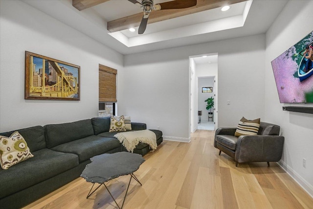 living room with light wood finished floors, ceiling fan, baseboards, and beamed ceiling