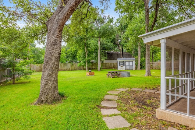 view of yard with a fenced backyard, a shed, and an outbuilding