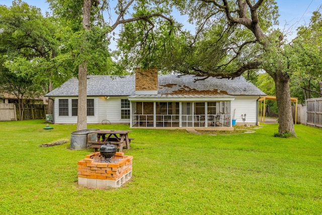 rear view of house featuring a fenced backyard, a sunroom, a yard, roof with shingles, and a chimney