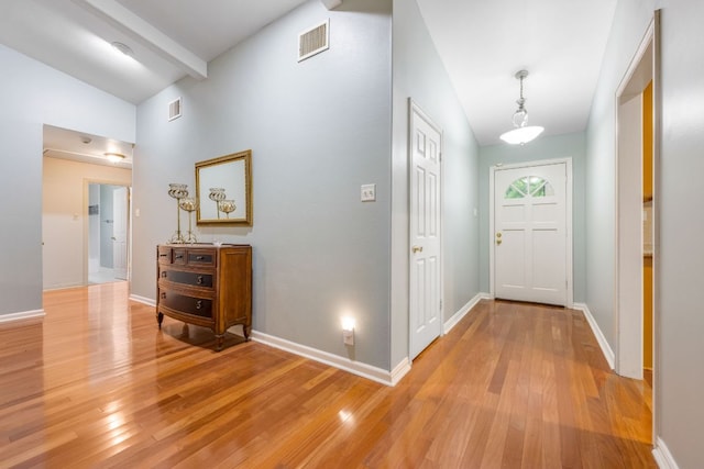 foyer entrance featuring light wood-style floors, baseboards, and visible vents