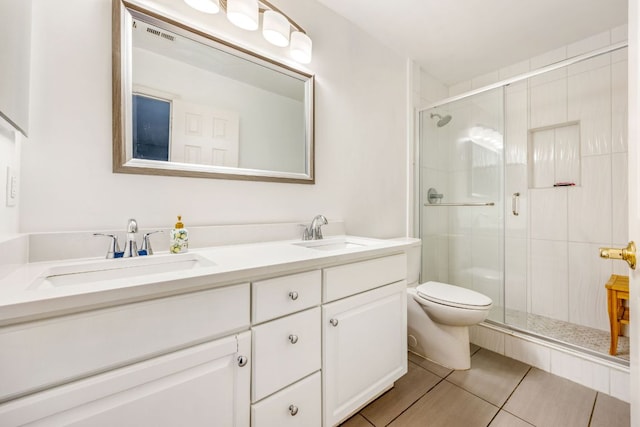 bathroom featuring a sink, a shower stall, toilet, and double vanity