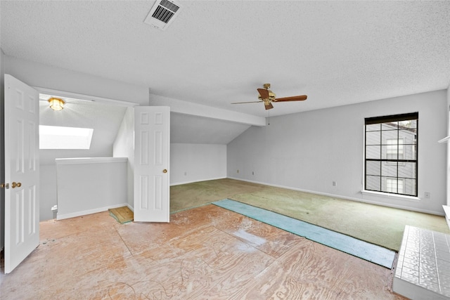 bonus room with vaulted ceiling, a textured ceiling, and visible vents