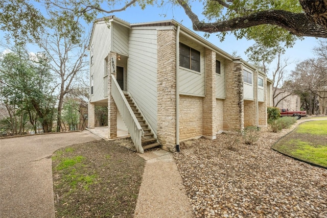 view of home's exterior with driveway and stairway