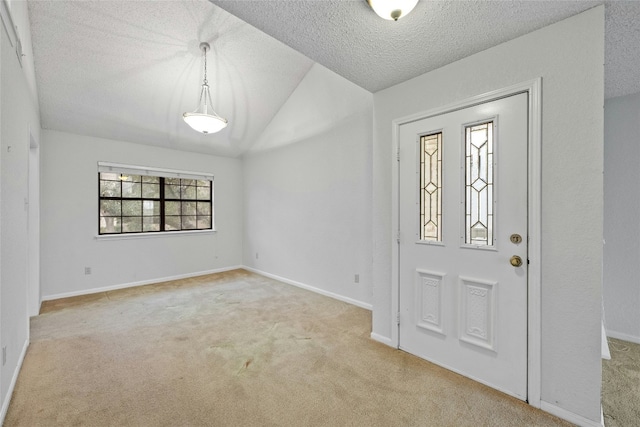 carpeted entrance foyer with lofted ceiling, a textured ceiling, and baseboards