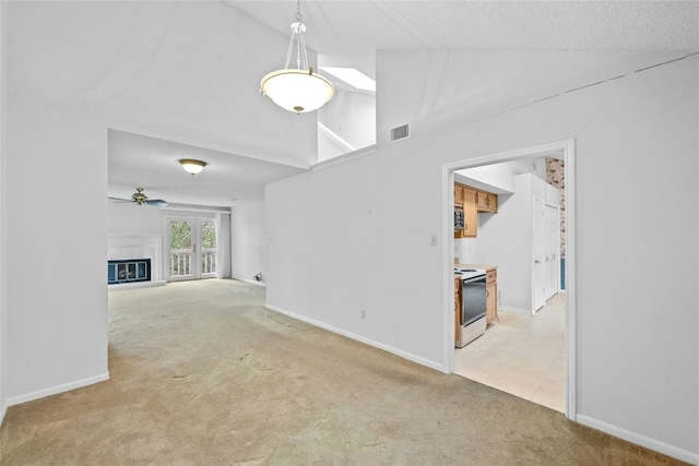 unfurnished living room featuring a glass covered fireplace, carpet flooring, visible vents, and baseboards