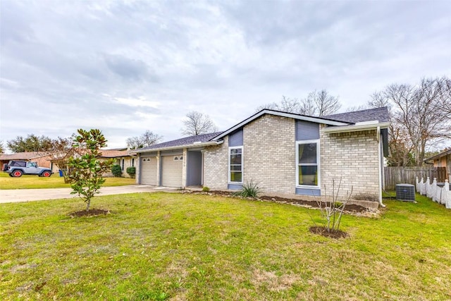 mid-century modern home featuring an attached garage, brick siding, fence, concrete driveway, and a front lawn