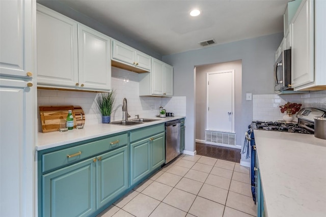 kitchen featuring stainless steel appliances, a sink, visible vents, and white cabinets