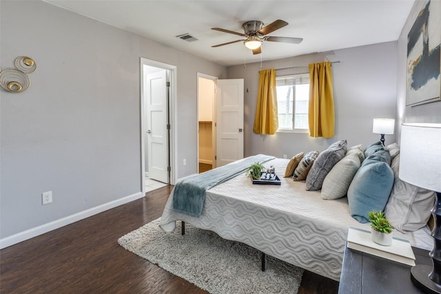 bedroom featuring visible vents, a ceiling fan, connected bathroom, wood finished floors, and baseboards