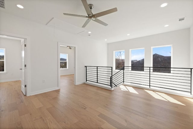 spare room with visible vents, light wood-style flooring, attic access, and recessed lighting