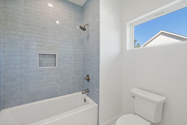 bathroom featuring bathtub / shower combination, toilet, and baseboards