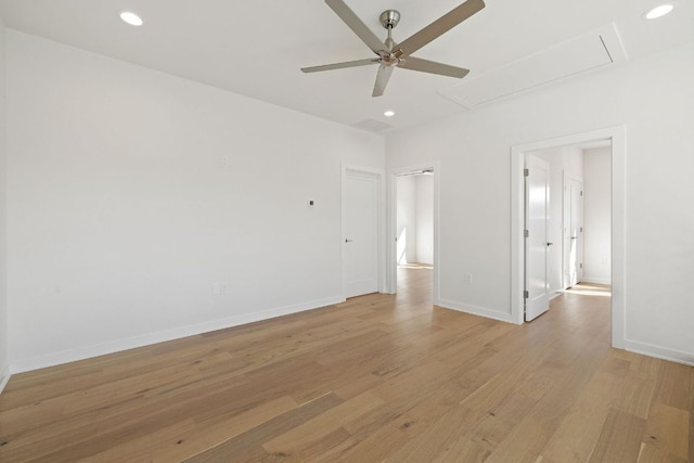 spare room with baseboards, light wood finished floors, attic access, and recessed lighting