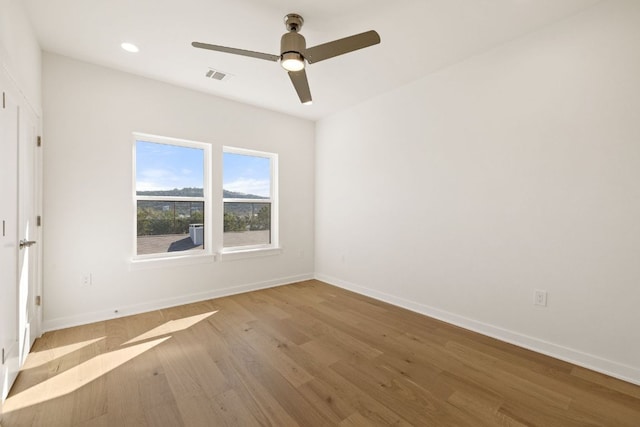 empty room featuring ceiling fan, recessed lighting, wood finished floors, visible vents, and baseboards