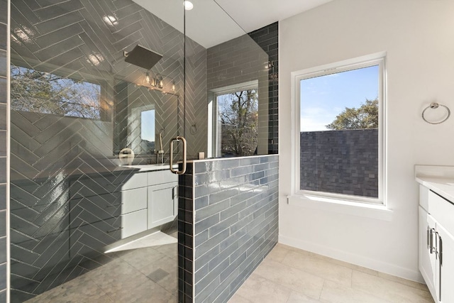 full bath featuring tiled shower, tile patterned flooring, and vanity