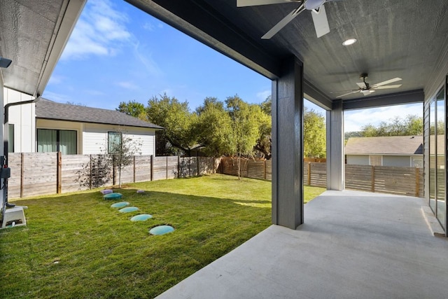 view of yard featuring a fenced backyard, ceiling fan, and a patio
