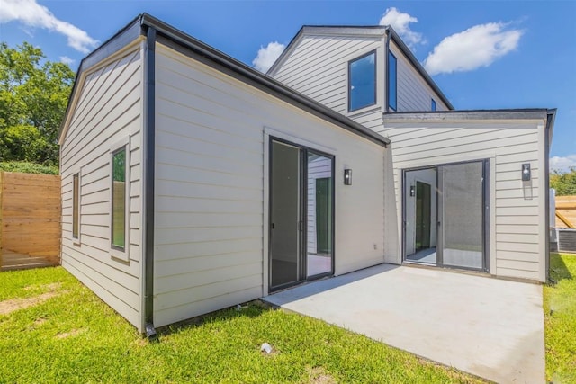 rear view of property with a yard, a patio area, and fence