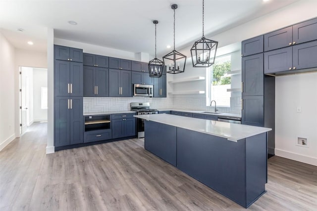 kitchen with appliances with stainless steel finishes, light countertops, a sink, and open shelves