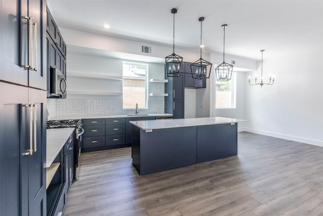 kitchen featuring stainless steel appliances, a sink, visible vents, open shelves, and tasteful backsplash