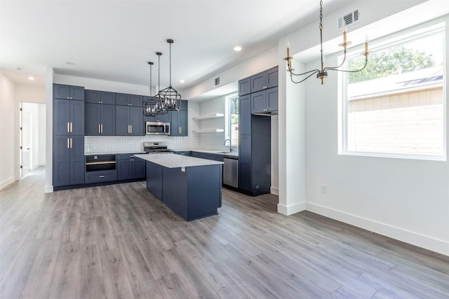 kitchen featuring a center island, open shelves, stainless steel appliances, visible vents, and backsplash