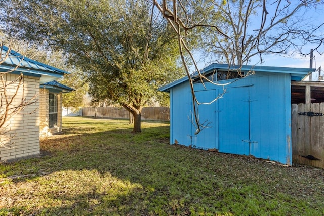 view of yard featuring a storage shed, a fenced backyard, and an outdoor structure