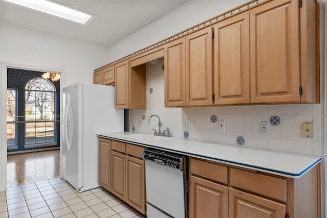 kitchen with a sink, decorative backsplash, light countertops, and dishwasher