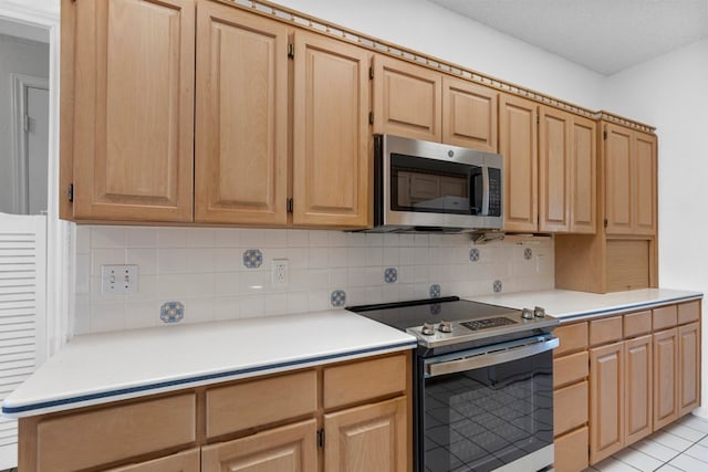 kitchen with stainless steel appliances, light countertops, backsplash, and light brown cabinets