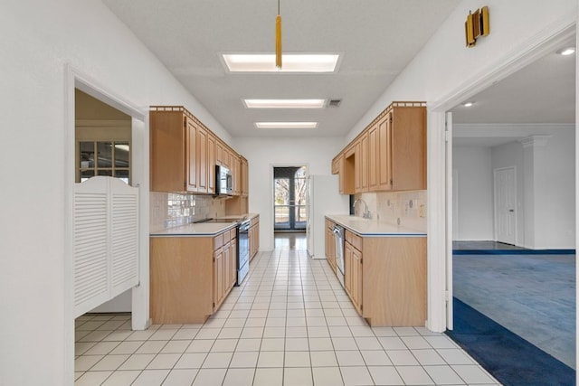 kitchen featuring light tile patterned floors, stainless steel appliances, light countertops, light carpet, and a sink