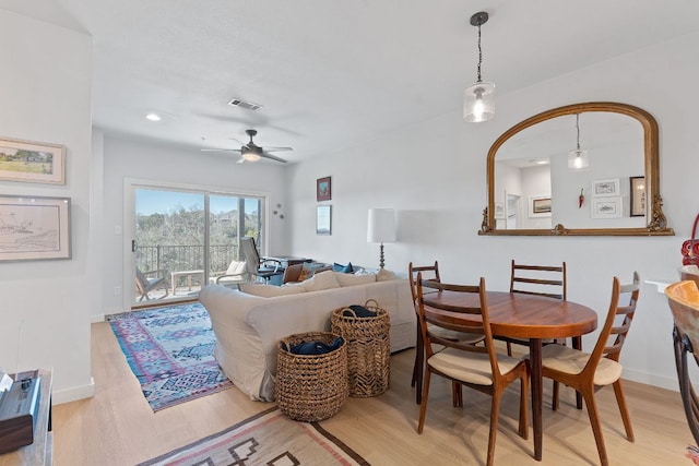 dining room with ceiling fan, light wood-type flooring, visible vents, and baseboards