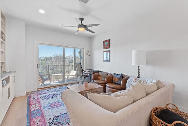 living area featuring light wood-style floors, baseboards, a ceiling fan, and recessed lighting