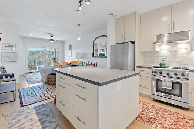 kitchen featuring stainless steel appliances, tasteful backsplash, visible vents, light wood-style flooring, and under cabinet range hood