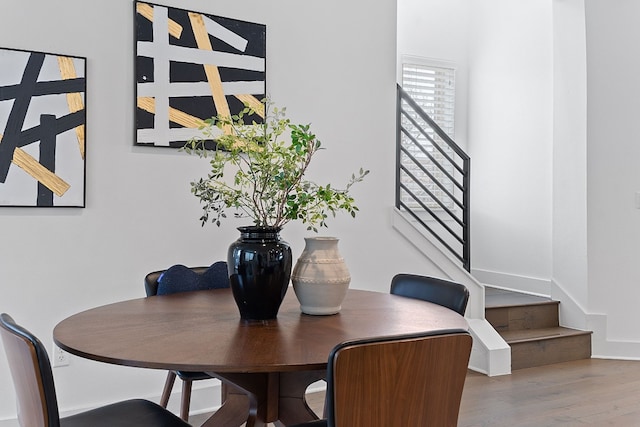 dining space featuring stairs and wood finished floors