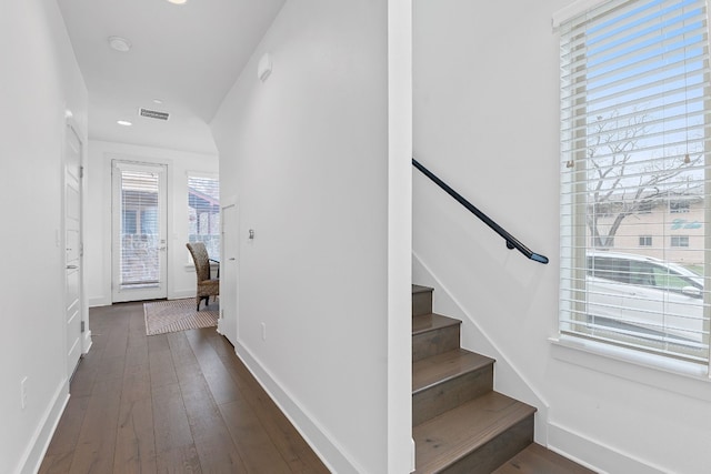 stairway with hardwood / wood-style floors, recessed lighting, visible vents, and baseboards