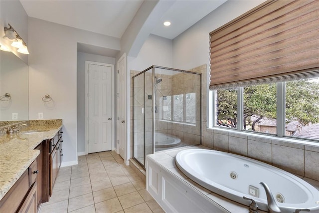 bathroom featuring a stall shower, vanity, tile patterned flooring, a jetted tub, and baseboards