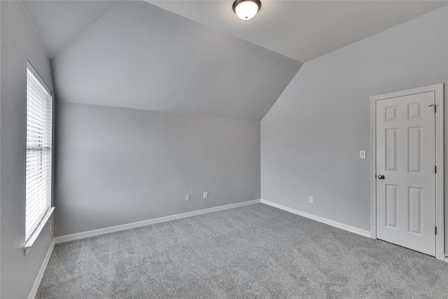 bonus room featuring lofted ceiling, baseboards, and carpet floors